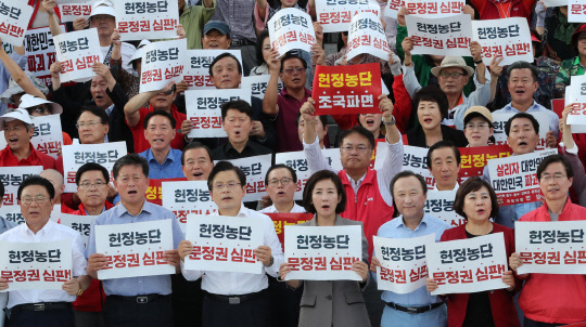 황교안 한국당 대표(앞줄 왼쪽 세번째)와 나경원 원내대표(네번째)가 15일 국회 본청 앞 계단에서 열린 '추석 민심 국민보고대회'에서 참석자들과 함께 구호를 외치고 있다.  연합뉴스